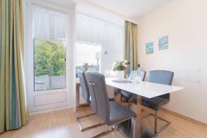 Un comedor con mesa y sillas y una ventana. en Strandappartements am Leuchtturmweg Leuchtturmblick, en Kellenhusen