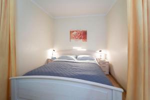 Dormitorio pequeño con cama con edredón azul en Strandappartements am Leuchtturmweg Leuchtturmblick, en Kellenhusen