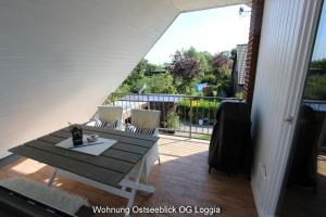 a patio with a table and chairs on a balcony at Kampenweg 8 Ostseeblick in Puttgarden