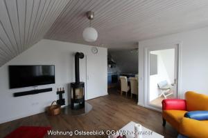 a living room with a fireplace and a tv at Kampenweg 8 Ostseeblick in Puttgarden