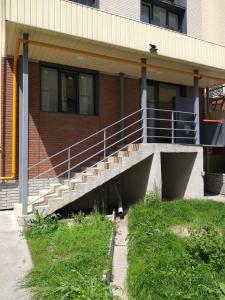 a building with stairs and grass in front of it at Hostel House ЖК Ожет in Almaty