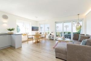a living room with a couch and a table at Villa Fördestrand Sehpferdchen in Laboe