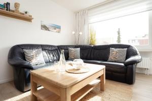 a black leather couch in a living room with a coffee table at Haus Wiking- Nordstern in Grömitz