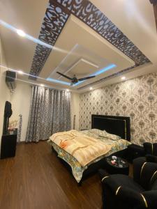 a bedroom with a bed and a couch in a room at Raheel house in Dargai