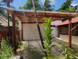 a house with a wooden pergola in front of it at Osmanthus private room in Punta Allen