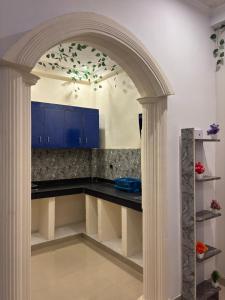 MalhourにあるVista Kove Flat - 101の青いキャビネットのあるキッチンに通じるアーチ道