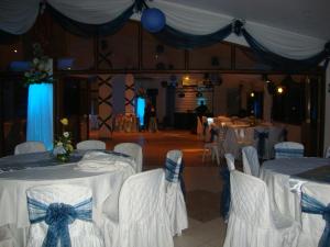 Habitación con mesas blancas y sillas con arcos azules en Hotel Sol del Oriente Iquitos en Iquitos