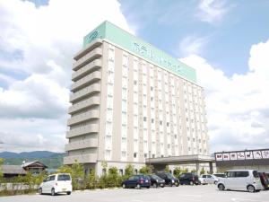 Un gran edificio blanco con un cartel encima. en Hotel Route-Inn Hikone, en Hikone