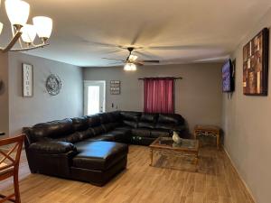 Una sala de estar con un sofá de cuero negro y una mesa. en Casa Las Vias 6 bed 4 bath & Private Pool, en Puerto Peñasco