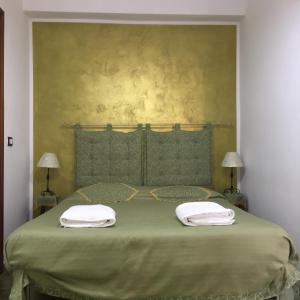 un letto verde con due asciugamani sopra di Casa Terme a Sciacca