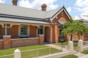 una casa de ladrillo con una valla delante en William House - Heart of Bathurst - Sleeps 6, en Bathurst