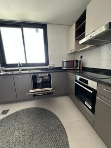 a kitchen with stainless steel appliances and a window at Sea & Lagoon View in The Wave in Muscat +11 photos