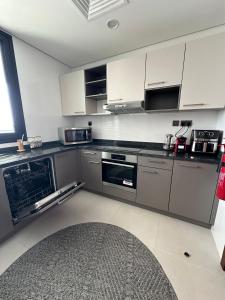 a kitchen with stainless steel appliances and white cabinets at Sea & Lagoon View in The Wave in Muscat