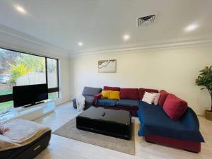 a living room with a couch and a flat screen tv at Liverpool Oasis 5BR Home for Groups and Families in Liverpool +16 photos
