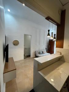 バニュワンギにあるnadien home stay Banyuwangiの白い壁のリビングルーム(大きなテーブル付)