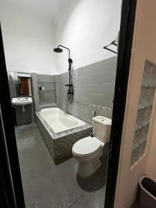 バニュワンギにあるnadien home stay Banyuwangiのトイレ、浴槽、洗面台を備えたバスルーム +9枚の写真