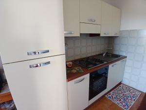 a kitchen with a white refrigerator and a stove at Sunset House in Mortigliano +10 photos