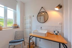 a bathroom with a sink and a mirror on the wall at Maison 8 pers plein centre ville in Lesneven