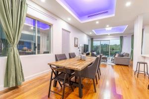 Un comedor con mesa y sillas de madera. en Luxury 5BD house w water view in Melrose Park, en Sídney