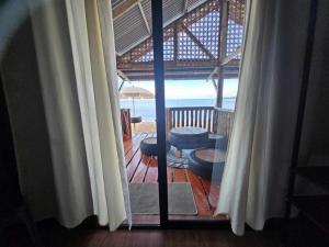 a room with a view of the beach through a window at Tambayan Rooms and Cottages by SMS Hospitality in Carmen