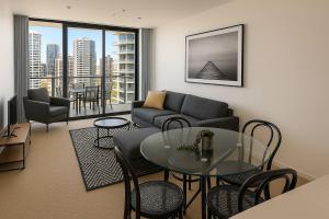 un soggiorno con un divano, un tavolo e delle sedie di Sun-Kissed Coastal Comfort Pool,Gym,Beach,BBQ a Gold Coast