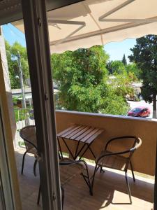 a balcony with a table and chairs and an umbrella at Family 2bdr 100sqm Airport 10min and Free Parking in Thessaloniki