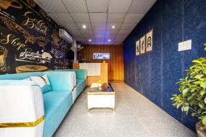 ノイダにあるHotel Vibe BLUE-Noida Sector 117の青いソファとテーブルのあるリビングルーム
