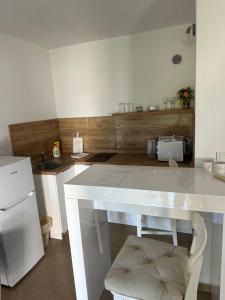 eine Küche mit einem weißen Tisch und einem Kühlschrank in der Unterkunft Villa Beba - Apartments in Senj