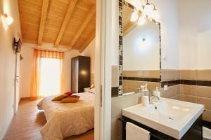 トレヴィーゾにあるB&B Al sogno di Lauraのベッドルーム(ベッド1台、シンク、鏡付)