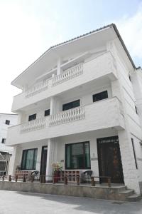 Un edificio blanco con ventanas y balcón. en 枕123民宿 宜蘭包棟民宿 依人數開房, en Yilan City