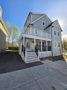 a large white house with a porch and stairs at Brand New 4BR House 20Min Downtown Boston in Boston