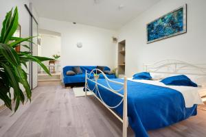 ein Schlafzimmer mit einem blauen Bett und einem Sofa in der Unterkunft Apartment Sapa in Split