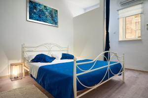 ein Schlafzimmer mit einem Bett mit einer blauen Decke in der Unterkunft Apartment Sapa in Split