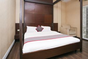 a bedroom with a large bed with a wooden frame at Collection O Cikarang Near Pollux Mall Formerly Hotel Pesona Cikarang in Cikarang
