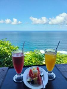 una mesa con dos bebidas y un plato de fruta en Nunggalan Octopus 3, en Uluwatu