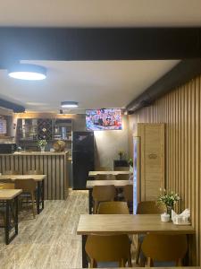 a dining room with tables and a tv on the wall at Boutique Hotel Tbili in Tbilisi City
