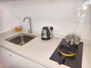 a kitchen with a pot on a stove with a sink at TR12 tulip elmina 5pax Big cinema movie 1 free parking in Shah Alam +19 photos