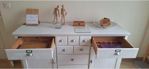 une commode blanche avec des tiroirs et une table avec un ordinateur portable dessus dans l'établissement 103m2 d'Espace et de Calme au coeur de Montpellier, à Montpellier