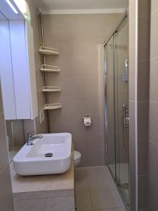 a bathroom with a sink and a shower and a toilet at Novaedil Apartment in Povljana +17 photos