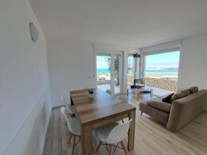 a living room with a table and chairs and the beach at Novaedil Apartment in Povljana