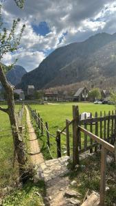 a wooden fence in a field with a horse at Petriti theth in Theth