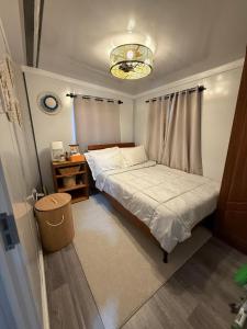 a small bedroom with a bed and a chandelier at Majuro Beachfront Container Home in Majuro
