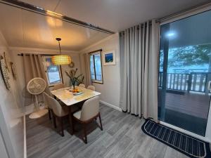 a dining room with a table and a large window at Majuro Beachfront Container Home in Majuro