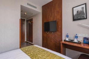 a hotel room with a bed and a flat screen tv at Yitel Beijing Tuanjiehu Metro Station in Beijing