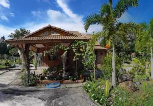 a house with a gazebo and a palm tree at Wangnamkhao Resort in Ban Huai Sai Khao
