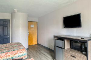 a hotel room with a bed and a flat screen tv at Relax Inn By Oyo Jackson MS Hwy 80 I-20 in Jackson