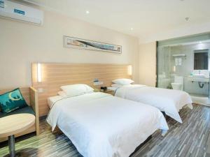 a hotel room with two beds and a bathroom at City Comfort Inn Yichang Gezhouba CBD Shopping Center in Yichang