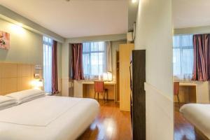 une chambre d'hôtel avec un lit, un bureau et des fenêtres dans l'établissement Warmly Hotel Suzhou Jinji Lake Ligongdi Branch, à Suzhou 217 autres photos