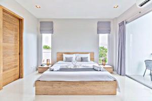 a bedroom with a large bed and a large window at Lemonade Phuket Hotel -SHA Plus in Chalong