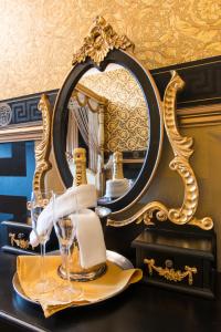 Maenan Abbey Hotel في لنروست: طاولة مع مرآة وصحن مع كؤوس للنبيذ